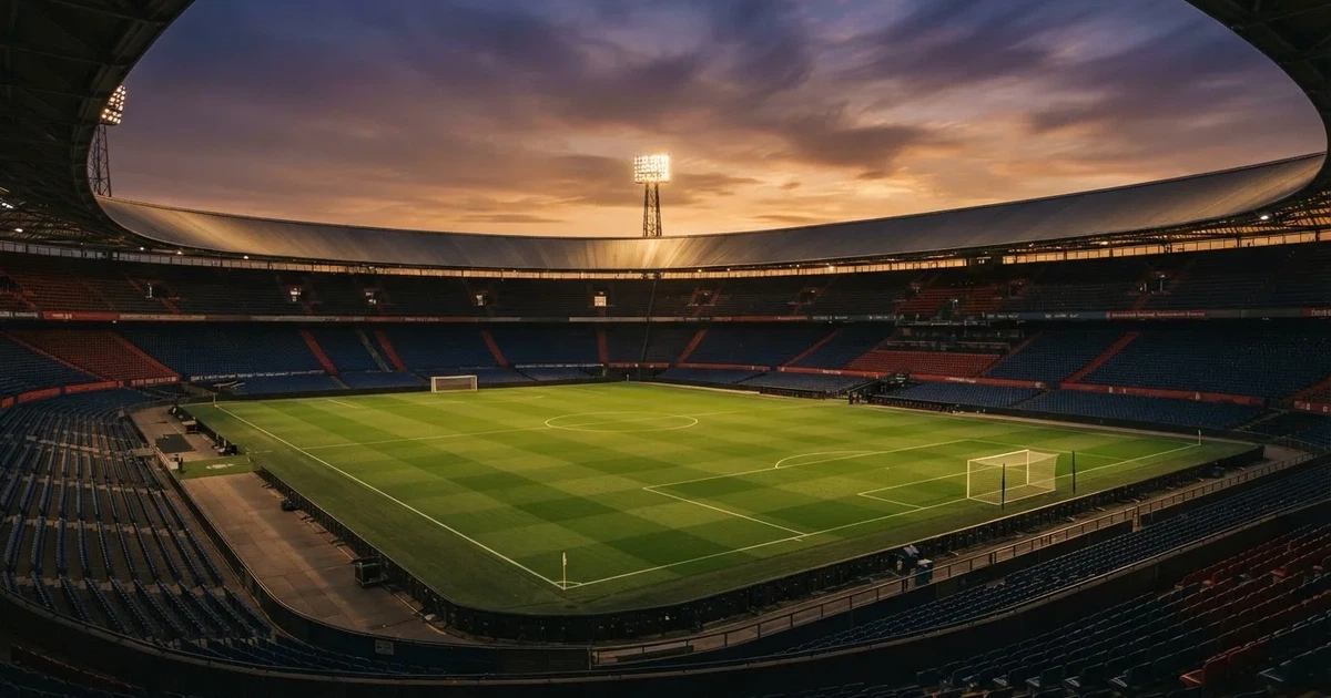 Un estadio de fútbol vacío con torres de iluminación al atardecer