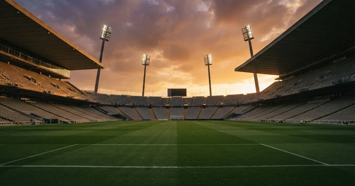Un estadio de fútbol vacío con torres de iluminación al atardecer